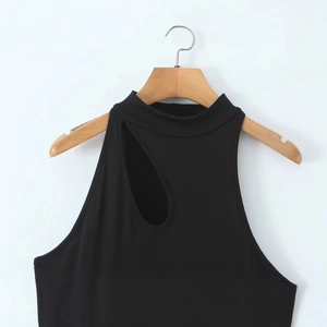Robe noire en maille sans manches avec découpe asymétrique sur un cintre en bois
