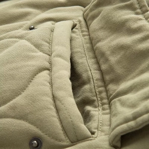 Vue détaillée d'une veste bomber en coton kaki avec texture matelassée et coutures de précision