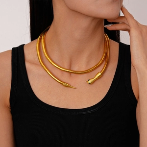 Golden snake-shaped necklace featuring gemstone eyes and detailed metallic texture