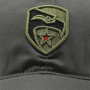 Detail showing high-density embroidery shield patch on cotton camo baseball cap
