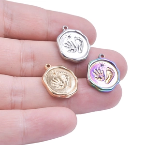 Three stainless steel handprint and footprint pendants in silver, gold and rainbow colors