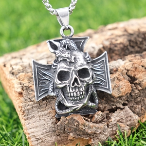 Gothic stainless steel necklace with snake wrapped around skull and cross pendant on wood