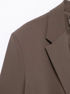 Detailed view of brown twill blazer lapel and shoulder tailoring with premium fabric texture