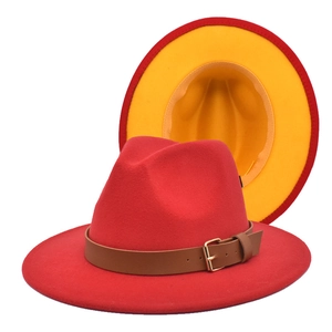 Detail of red wool fedora hat featuring a brown leather band and yellow contrast lining