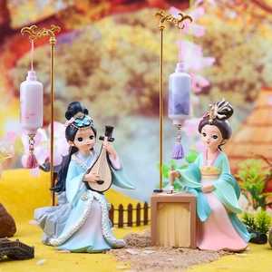 Detail of traditional Chinese resin figurines playing lute and writing with lanterns