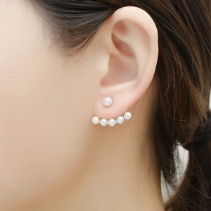 Détail de boucles d'oreilles en éventail en or 18 carats avec perles blanches sur mannequin