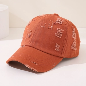 Detail of burnt orange distressed kids baseball cap showing herringbone texture and tears