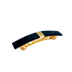Detail of a black acetate rectangular hair clip with a textured gold metal center square
