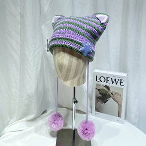 Cute knitted cat ear hat with purple and green stripes and faux fur pom-pom ties