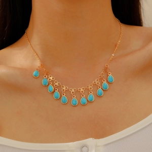 Detail shot of bohemian gold necklace with thirteen water drop turquoise stones on model