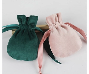 Detail of premium velvet drawstring bags in dark green and pink with satin ribbons