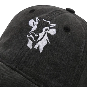 Close-up of cow embroidery on vintage washed canvas baseball cap showing fine stitching