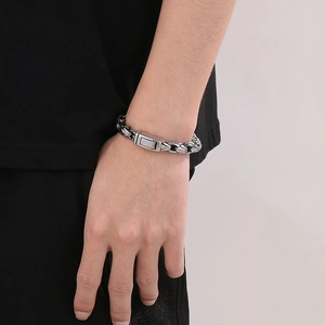 Close-up of a 10mm stainless steel curb chain bracelet with rectangular clasp on wrist