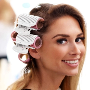 Close-up of pink hair rollers with white clips used on hair for salon styling