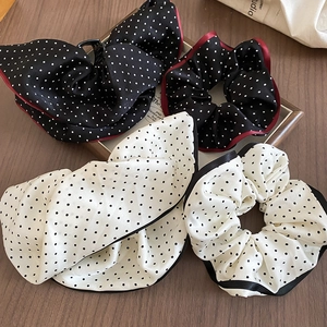 Close-up of polka dot fabric scrunchies and bow hair clips on a wooden surface