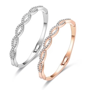 Close-up of twisted hollow silver and rose gold Christmas bracelets with shiny crystals