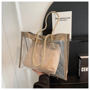 Detail of transparent PVC tote bag with beige woven handles and inner pouch bag
