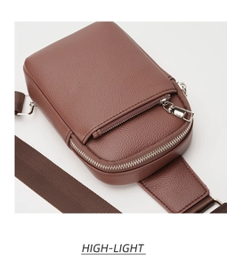 Detail of brown litchi pattern leather crossbody bag with silver double metal zippers