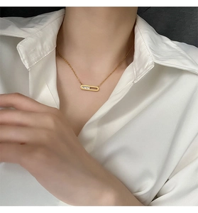 Detail view of gold 18K plated rectangular pendant with three sliding zircon stones