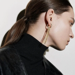 Close-up of golden long tassel heart earrings on model for a trendy fashion look