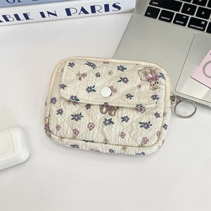 Quilted cotton pouch with purple floral and bear prints on a desk with a laptop