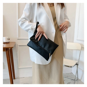 Elegante bolso de mano de piel sintética negra con cremallera dorada y asa lateral