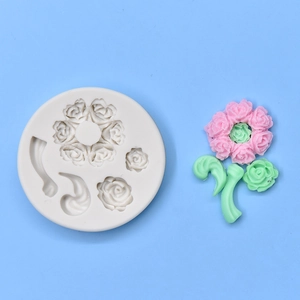 Close-up of silicone mold with flower and leaf shapes next to pink clay art