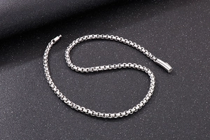 Detailed close-up of a silver stainless steel box chain with a cylindrical plug-in clasp