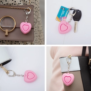 Pink heart-shaped personal safety alarm attached to handbags and keychains