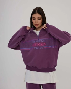 Detail of purple half-zip sweatshirt featuring geometric prints and knit texture fabric