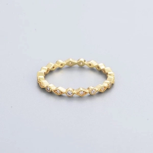 Dettaglio dell'anello in oro rosa con motivi geometrici a rombo e zirconi incastonati
