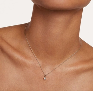 Close-up of S925 silver heart lock necklace with diamond accent on model's neckline