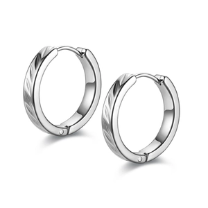 Detailed close-up of silver titanium steel earrings with engraved leaf textures