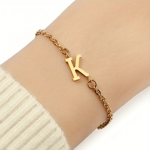 Nahaufnahme eines zarten 18K vergoldeten Kettenarmbands mit einem markanten Buchstaben-K-Anhänger