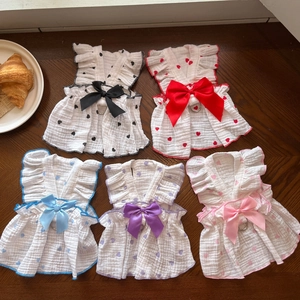 Flat lay of heart pattern pet harness dresses in five colors on a wooden background