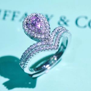 Detailed macro view of pear shaped pink moissanite ring with double halo setting