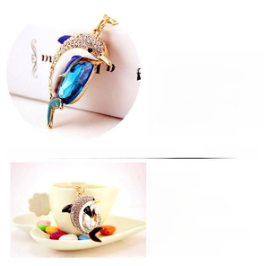 Detailed macro view of crystal rhinestone dolphin pendants in blue and white colors
