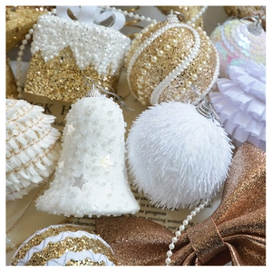 Close-up of champagne gold glitter Christmas ornaments with pearls, bells and stars