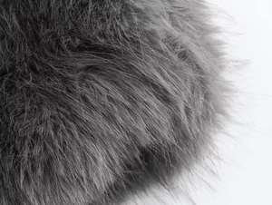 Macro shot of grey faux fur texture showing fine fibers and silky gloss on jacket