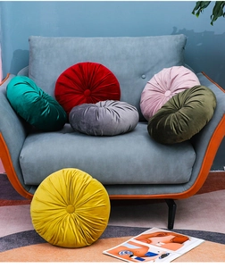Detail of round pleated velvet pumpkin cushion showing textures and center button