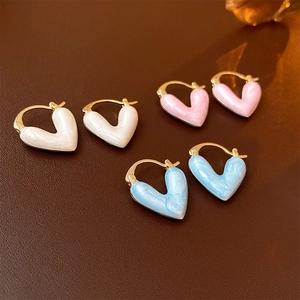 Vue détaillée de boucles d'oreilles cœur en émail plaqué or en blanc, rose et bleu