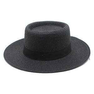 Detail of classic black woven straw boater hat with flat crown and wide decorative ribbon