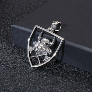 Gros plan du pendentif pirate en acier argenté avec casque viking sur écrin texturé