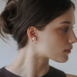Minimalist silver brass ear cuff with single white pearl shown on model side profile