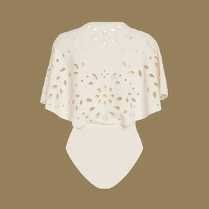 Detail of laser-cut floral pattern on the back of beige one-piece swimwear