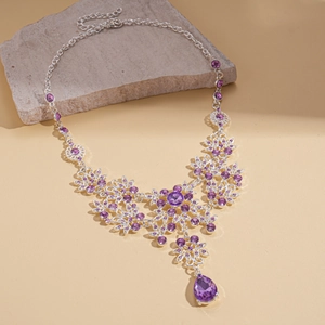 Detailed macro view of retro purple teardrop zircon pendant and hollow flower necklace