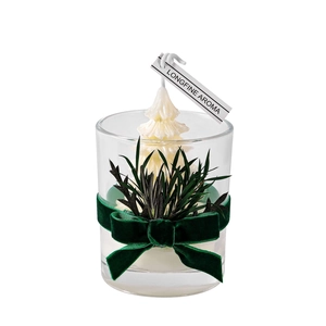 Handmade Christmas tree scented candle in glass jar with green ribbon and foliage