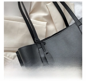 Detail of reinforced stitching and lychee grain leather on black tote bag handle