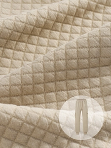 Dettaglio della trama a nido d'ape beige sui pantaloni da uomo con tasca e coulisse