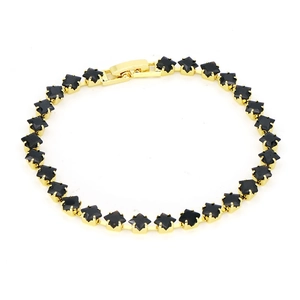 Macro shot of 18k gold tennis bracelet featuring square black zircon stones and clasp